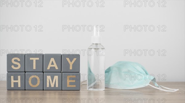 Wooden cubes with stay home hand sanitizer medical mask