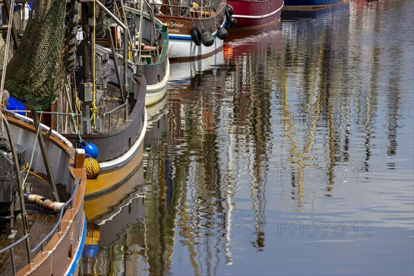 Crab cutter with reflection in the water in the harbour of Greetsiel