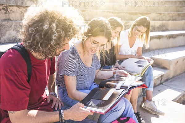 Cheerful students studying stairs