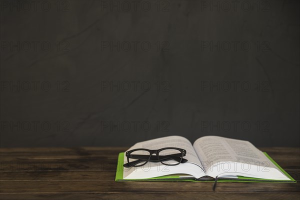 Opened book with glasses table