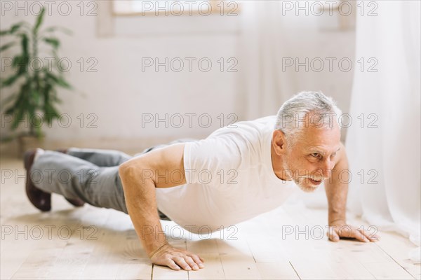 Senior man doing pushup exercise hardwood floor