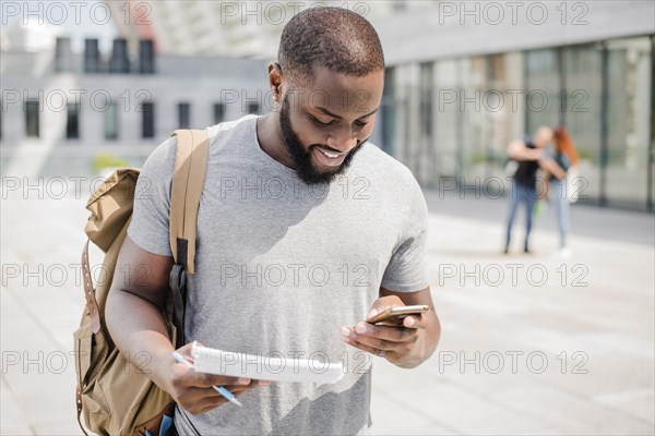 Cheerful student using phone