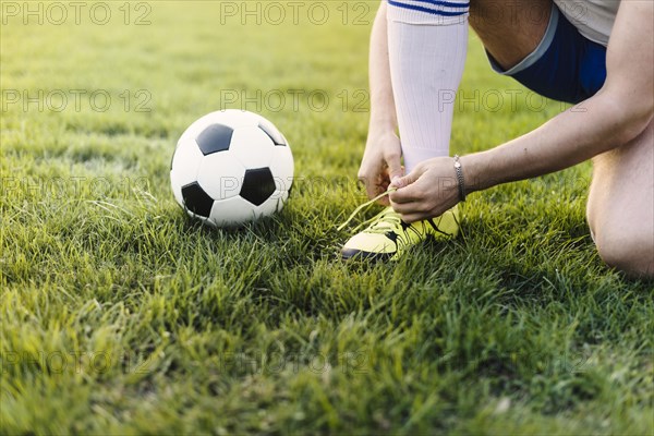 Crop sportsman tying laces field