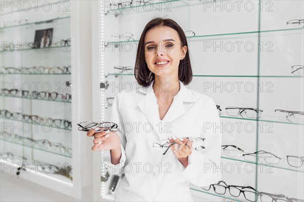 Medium shot optician holding glasses frames