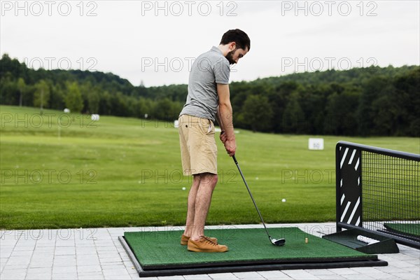 Professional golf player practising golf field