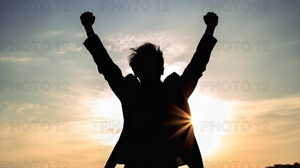 Excited businessman celebrates with his fists in the air with the city in the background