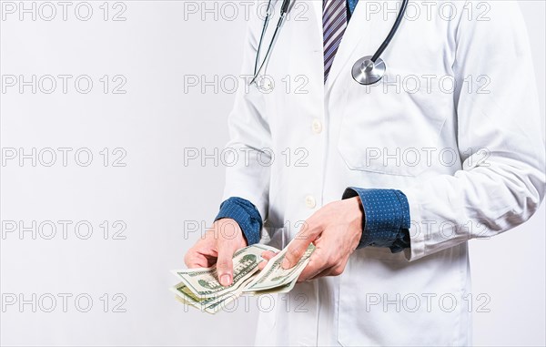 Corrupt doctor counting money isolated. hands of corrupt doctor counting money on isolated background