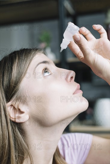 Close up woman putting eye drops