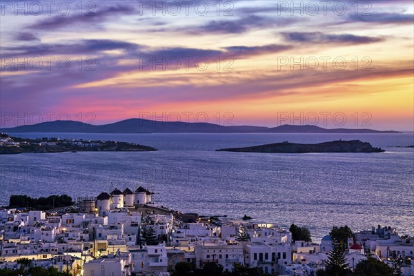 Beautiful sunset view of famous traditional white windmills on top of hill of Chora