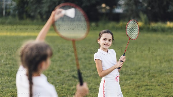 Two girls playing badminton park