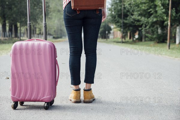 Back view young girl with pink luggage park