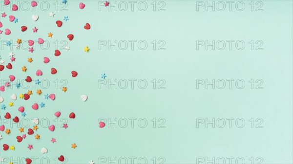 Stars hearts confetti turquoise background with copy space