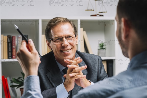 Portrait mature happy lawyer sitting with client