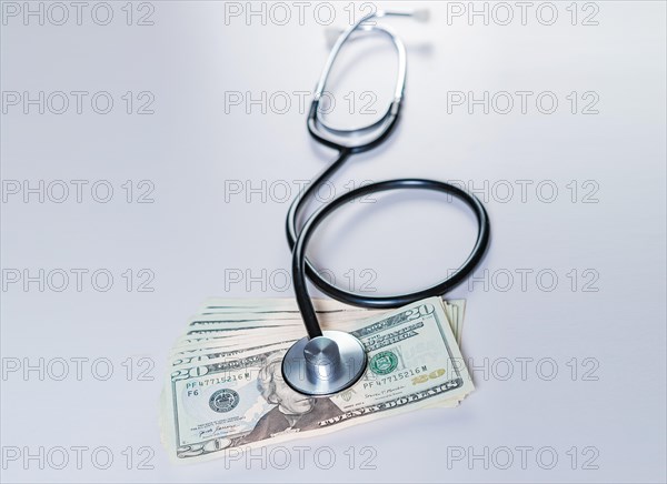 Stethoscope on dollar bills isolated. Stethoscope on top of dollar bills isolated