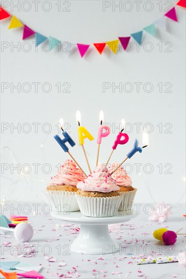 Front view birthday cupcakes with lit candles