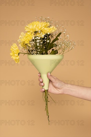 Close up woman hand with plastic funnel with flowers