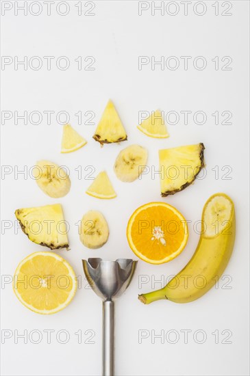 Electric blender with pineapple banana orange slices isolated white background