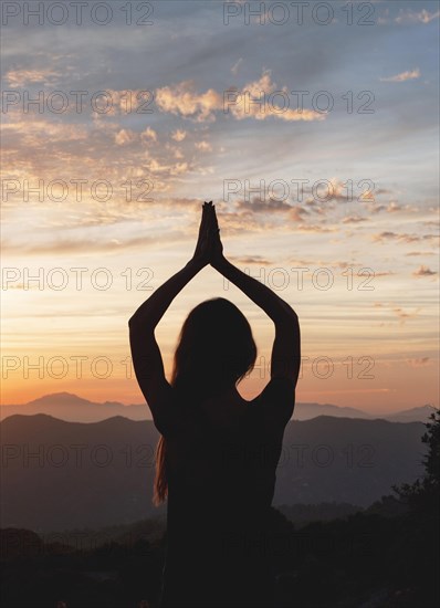 Back view woman yoga pose during sunset