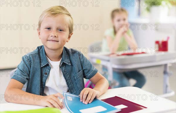 Blonde kid sitting his desk