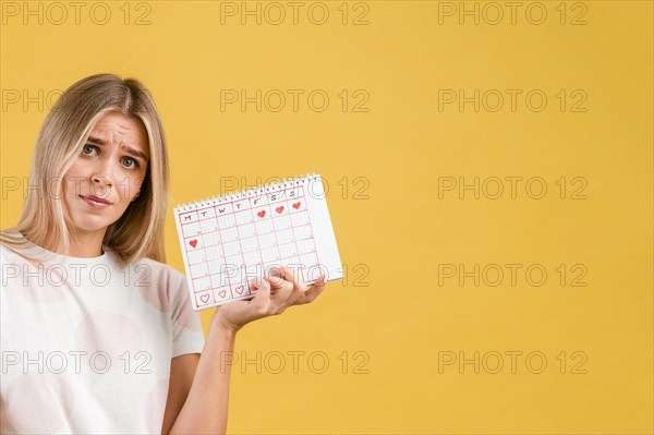 Woman being upset holding period calendar
