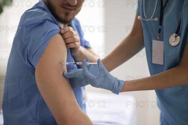Female doctor vaccinating her colleague