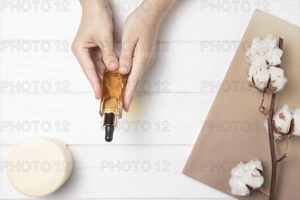 Flat lay hands holding body care product wooden background