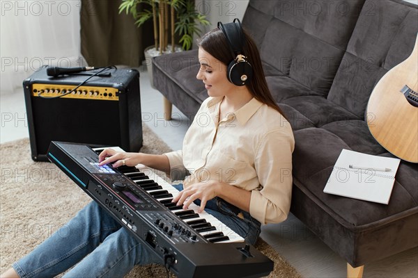 High angle female musician playing piano keyboard