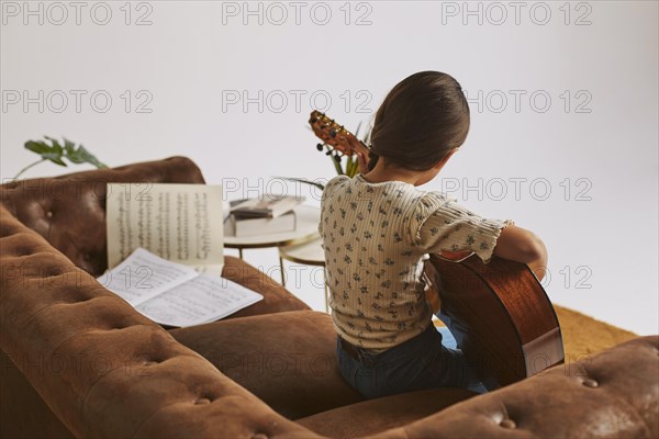 Little girl learning how play guitar home