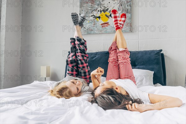 Women lying bed holding up crossing legs