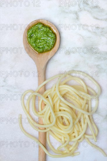 Pesto in cooking spoon and spaghetti