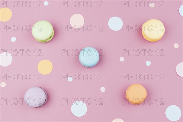 Arranged colorful macaroons with confetti top view