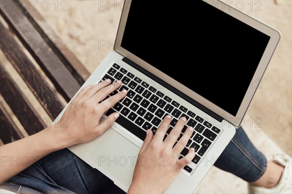 Girl sitting bench with laptop
