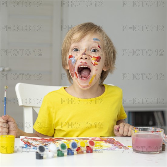 Playful boy painting