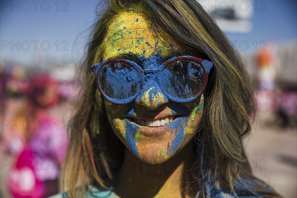 Blue yellow holi color powder woman s face