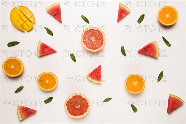 Sliced grapefruit watermelon orange mango green leaves