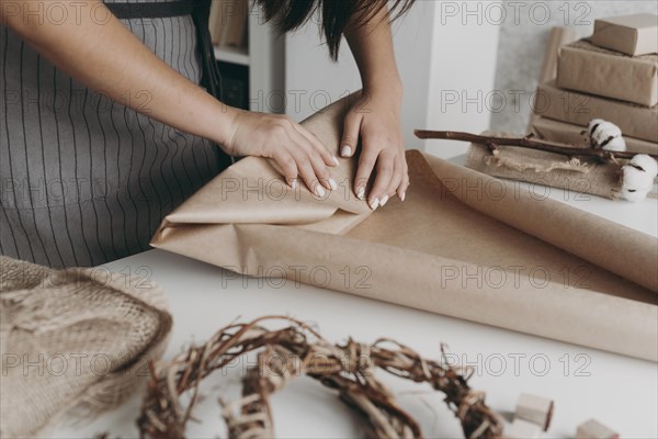 Close up hands wrapping paper