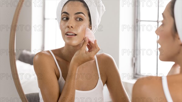 Young beautiful woman using foundation cream