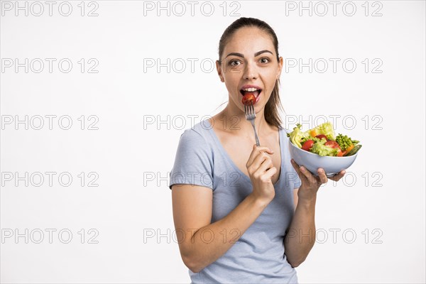Woman eating tomato with fork