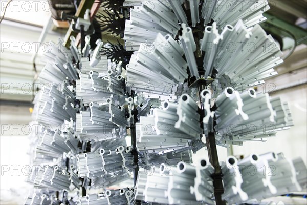 Profiles hanging from a dipping device in a galvanising plant