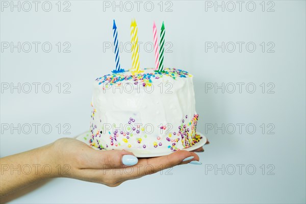 Hands holding cake with sprinkles