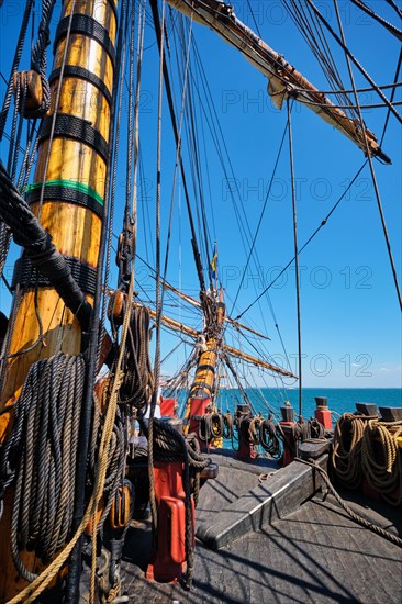 Deck with mast and ropes and bowspirit of wooden Age of sail sailing ship