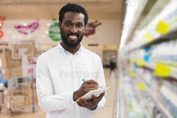 Man checking off items shopping list