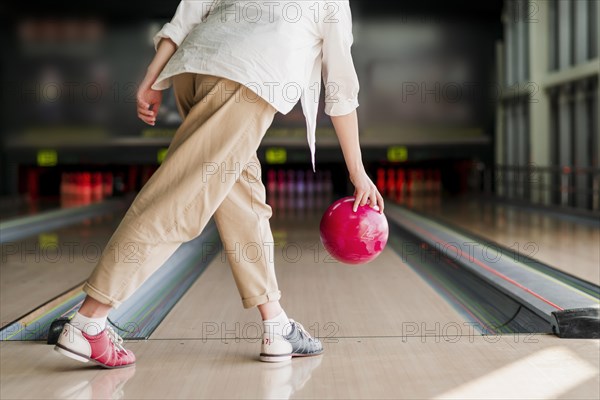 Person throwing red bowling ball