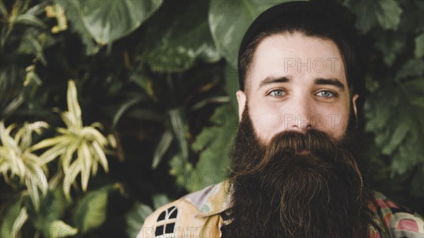 Panoramic view bearded young man looking camera