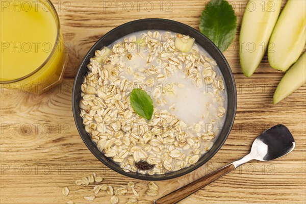 Oatmeal porridge bowl with cup orange juice