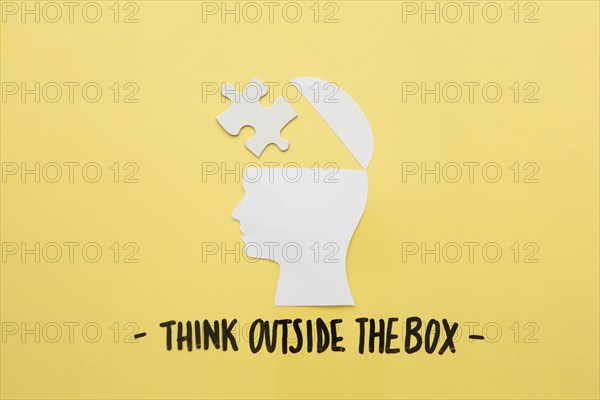 Open human brain with jigsaw piece near think outside box message