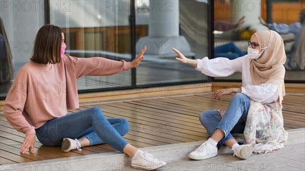 Full shot women sitting distance