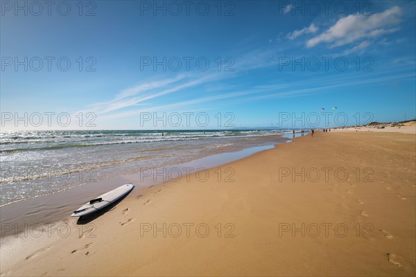 Sandy Atlantic ocean beach with surfboard at Fonte da Telha beach