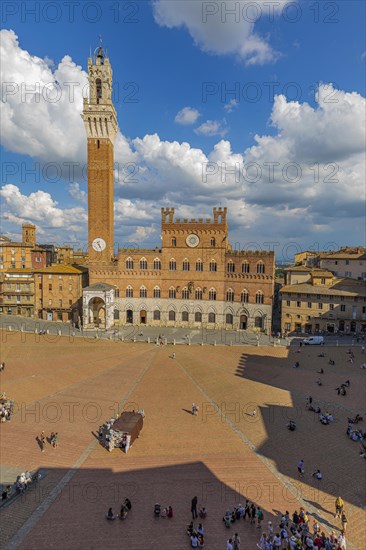 Spring clouds over the Piazza del Campo with the bell tower Torre del Mangia and the town hall Palazzo Pubblico