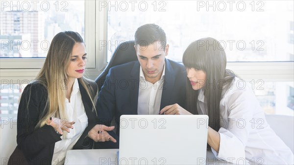 Business people looking laptop having discussion meeting